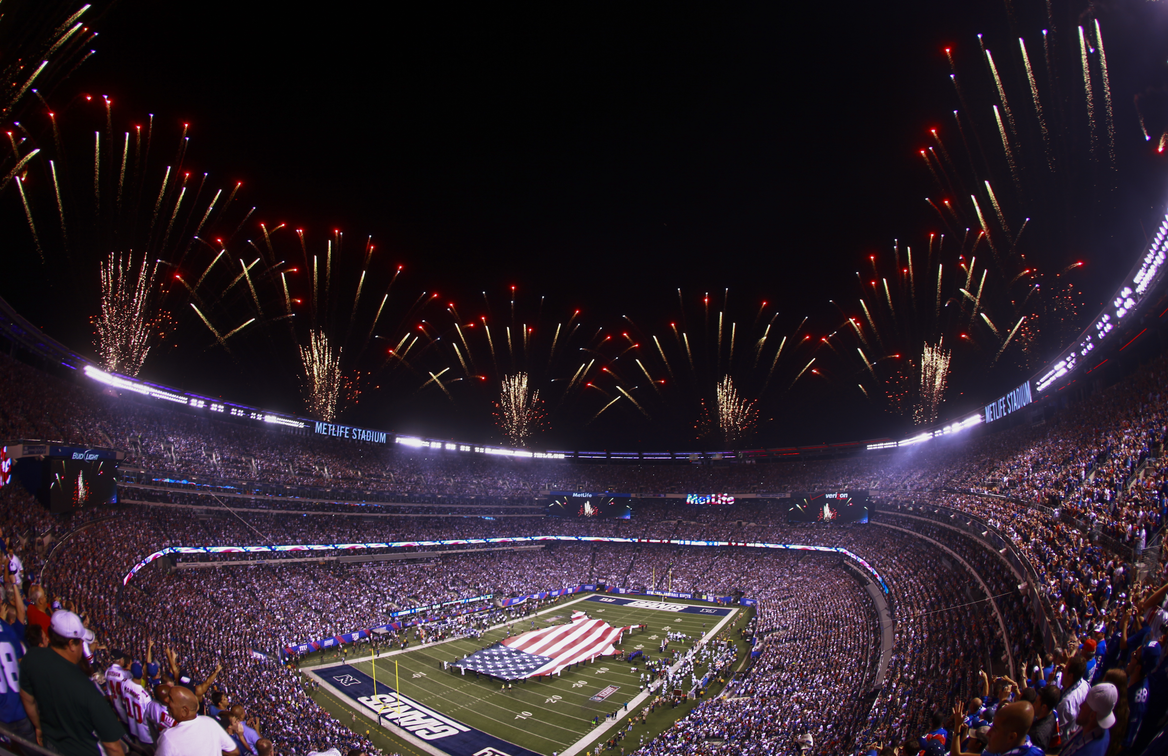 MetLife Stadium lotado durante evento noturno com fogos de artificio