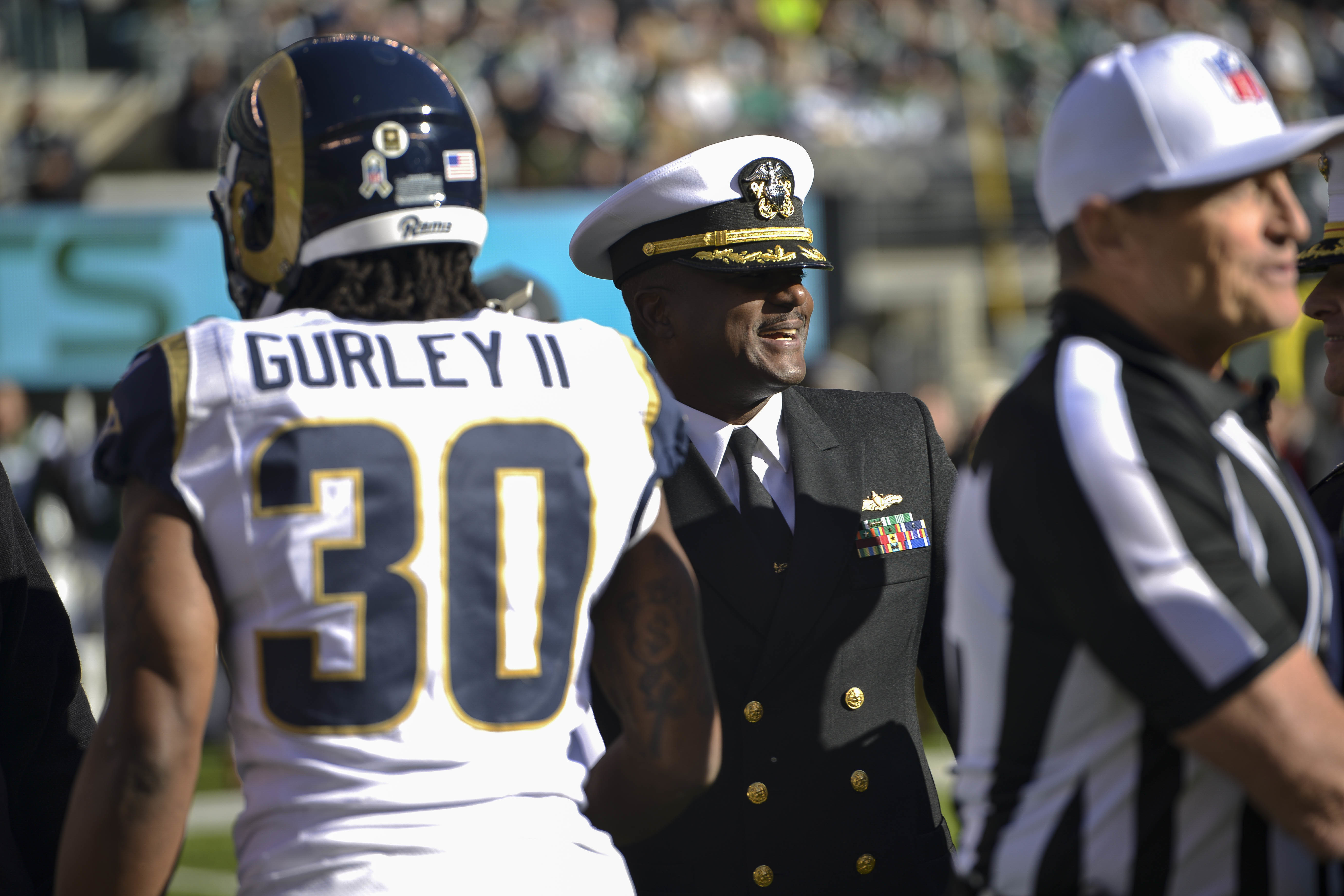 Interacao entre jogador e oficial no campo do MetLife Stadium durante jogo da NFL